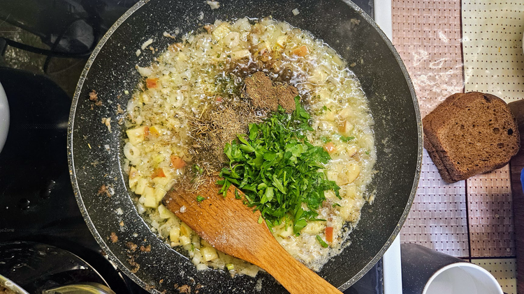 Крок 6. Цибуля, яблука, зелень, спеції на пательні.